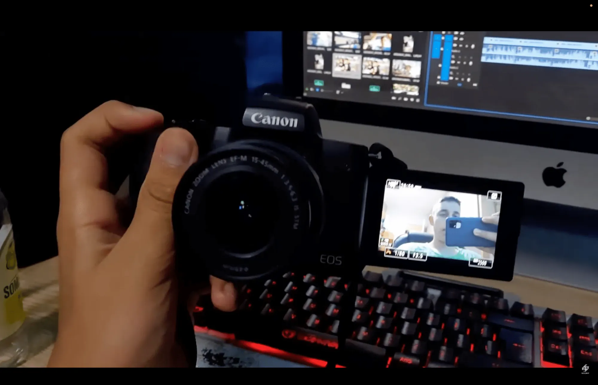 Canon EOS M50 u ruci ispred monitora sa montažom